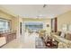 Bright living room with tile flooring, ceiling fan, stylish furnishings, and a sliding door leading to a screened patio overlooking the lake at 1940 Scarlett Ave, North Port, FL 34289