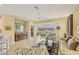 Bright living room with tile flooring, ceiling fan, stylish furnishings, and a sliding door leading to a screened patio overlooking the lake at 1940 Scarlett Ave, North Port, FL 34289