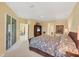 Spacious main bedroom with a ceiling fan, sliding glass doors to the lanai, and a view of the en suite at 1940 Scarlett Ave, North Port, FL 34289
