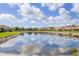 Community pond view, with homes in the background and trees surrounding at 1940 Scarlett Ave, North Port, FL 34289