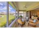 Bright sunroom with comfortable seating overlooking well-maintained yard and lake at 1940 Scarlett Ave, North Port, FL 34289
