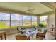 Relaxing sunroom with four chairs and panoramic views of the lake and landscaping at 1940 Scarlett Ave, North Port, FL 34289