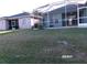 View of grassy backyard with screen enclosures at 2241 Boxwood St, North Port, FL 34289