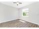 This bedroom has wood-look floors, neutral walls, and a window with blinds for natural light at 2241 Boxwood St, North Port, FL 34289