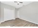 Bedroom boasts wood-look floors, white walls, a ceiling fan, and closet with bright white doors at 2241 Boxwood St, North Port, FL 34289