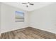 Bedroom featuring wood-look floors and a window with blinds that provides natural light at 2241 Boxwood St, North Port, FL 34289