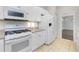 Clean white kitchen featuring modern appliances, ample counter space, and tiled floors for easy maintenance at 2241 Boxwood St, North Port, FL 34289
