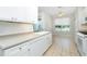 Eat-in kitchen with white cabinets, tile floors, stainless appliances, and window view at 2241 Boxwood St, North Port, FL 34289