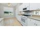 Eat-in kitchen with white cabinets, tile floors, stainless appliances, and window view at 2241 Boxwood St, North Port, FL 34289