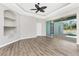 Bright living room featuring hardwood floors, a tray ceiling, and access to a screened-in pool area at 2241 Boxwood St, North Port, FL 34289