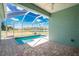 Corner view of screened-in pool with view of backyard and lake at 2241 Boxwood St, North Port, FL 34289