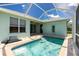 Backyard pool area under screened enclosure with brick-paved decking at 2241 Boxwood St, North Port, FL 34289
