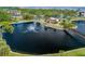 Aerial view of the community showing the lake with fountain, clubhouse, and surrounding landscape at 23465 Harborview Rd # 915, Punta Gorda, FL 33980
