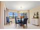 Bright dining area features tiled flooring, a round glass table, blue upholstered chairs, and natural light at 23465 Harborview Rd # 915, Punta Gorda, FL 33980