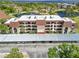Exterior of the community condo building featuring ample covered parking and manicured landscaping at 23465 Harborview Rd # 915, Punta Gorda, FL 33980