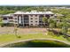 Exterior of the community condo building with arched balconies and a scenic pond view with lush lawn at 23465 Harborview Rd # 915, Punta Gorda, FL 33980