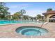 Community hot tub and pool featuring brick-paved surround and lounge seating at 23465 Harborview Rd # 915, Punta Gorda, FL 33980