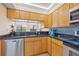 Charming kitchen boasts wooden cabinetry, granite countertops, stainless steel dishwasher, and a pass-through window at 23465 Harborview Rd # 915, Punta Gorda, FL 33980