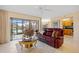 Inviting living room featuring tile floors, comfortable seating, and a slider leading to a screened-in porch and water views at 23465 Harborview Rd # 915, Punta Gorda, FL 33980