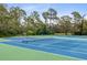 Well-maintained community tennis court surrounded by mature trees and lush landscaping at 23465 Harborview Rd # 915, Punta Gorda, FL 33980
