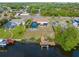 A view of the backyard featuring a screened in pool, large patio, and dock with boat lift on a canal at 2368 Pellam Blvd, Port Charlotte, FL 33948