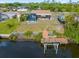 A view of the backyard featuring a screened in pool, patio, and a dock with boat lift on a canal at 2368 Pellam Blvd, Port Charlotte, FL 33948