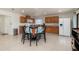 Bright kitchen area featuring oak cabinetry, granite counters, and dining table with natural lighting at 2368 Pellam Blvd, Port Charlotte, FL 33948