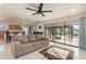 Comfortable living room featuring neutral décor, tile floors, fan, and sliding glass doors to outdoor area at 2368 Pellam Blvd, Port Charlotte, FL 33948