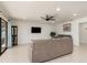 Spacious living room with tiled floors, ceiling fan, tv, and sliding glass doors for natural lighting at 2368 Pellam Blvd, Port Charlotte, FL 33948