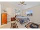 Comfortable bedroom with ceiling fan, neutral carpet, and a large window with views of the outdoors at 25313 Durango Ct, Punta Gorda, FL 33955