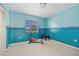This exercise room has blue walls, carpeted floors, an exercise chair, and a window with views of the yard at 25313 Durango Ct, Punta Gorda, FL 33955