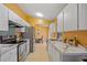 Bright kitchen with white cabinets, stainless steel appliances, and tile floors opens to the dining area at 25313 Durango Ct, Punta Gorda, FL 33955