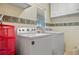 Bright laundry room with a washer, a dryer, upper cabinets and a window at 25313 Durango Ct, Punta Gorda, FL 33955