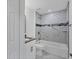 Modern bathroom featuring marble tiling, a shower-tub combo, and a granite vanity at 26384 Flower Rd, Punta Gorda, FL 33955