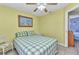 Bright bedroom with a queen-sized bed, ceiling fan, and tropical-themed decor at 2679 Pascal Ave, North Port, FL 34286