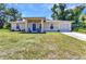 Charming single-story home featuring a blue front door and well-maintained lawn with mature trees and a one car garage at 2679 Pascal Ave, North Port, FL 34286