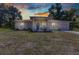 Charming single-story home with a blue front door, and well-maintained lawn under a sunset sky and mature trees at 2679 Pascal Ave, North Port, FL 34286