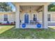 Inviting front porch with seating, blue flower pots, and a charming blue door with decorative elements and sea horse decorations at 2679 Pascal Ave, North Port, FL 34286