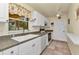Cozy kitchen featuring white cabinetry, a double sink, and a window offering views of the outdoors at 2679 Pascal Ave, North Port, FL 34286