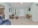 Light and bright living room featuring tile floors, light blue walls, ceiling fan and a glass panel front door at 2679 Pascal Ave, North Port, FL 34286