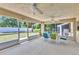 Enclosed patio with ample seating, ceiling fans, and views of the backyard at 2679 Pascal Ave, North Port, FL 34286
