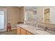Bathroom with a dual sink vanity featuring a granite countertop and a door leading to the outside at 2699 Suncoast Lakes Blvd, Punta Gorda, FL 33980