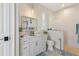 Bathroom with white vanity, blue tiling, and step-in shower behind glass panel at 2850 Magdalina Dr, Punta Gorda, FL 33950