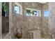 This walk-in shower has a small bench, decor and three windows for natural light at 2850 Magdalina Dr, Punta Gorda, FL 33950