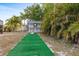 Outdoor bar area with seating surrounded by lush tropical greenery and artificial turf at 3078 Mancini Ter, Punta Gorda, FL 33983