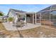 A spacious backyard featuring a patio, grill, an adjacent screened-in porch, and a pool at 3078 Mancini Ter, Punta Gorda, FL 33983