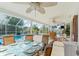 Covered patio with ceiling fans, table, chairs, and view of the screened in pool at 3078 Mancini Ter, Punta Gorda, FL 33983