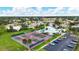 Aerial view of tennis courts, pickleball courts, and a community pool surrounded by lush greenery at 3287 Meadow Run Cir, Venice, FL 34293
