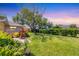 Landscaped backyard featuring a mature tree providing shade and lush green lawn at 3287 Meadow Run Cir, Venice, FL 34293