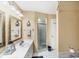 Bathroom with dual sinks, nautical-themed decor, and a glass enclosed walk-in shower at 3287 Meadow Run Cir, Venice, FL 34293